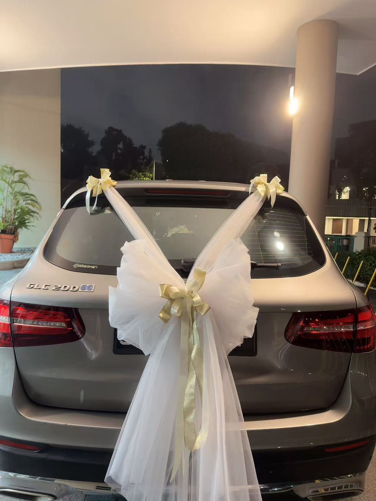Rear view featuring grand white tulle bow with gold ribbon accents